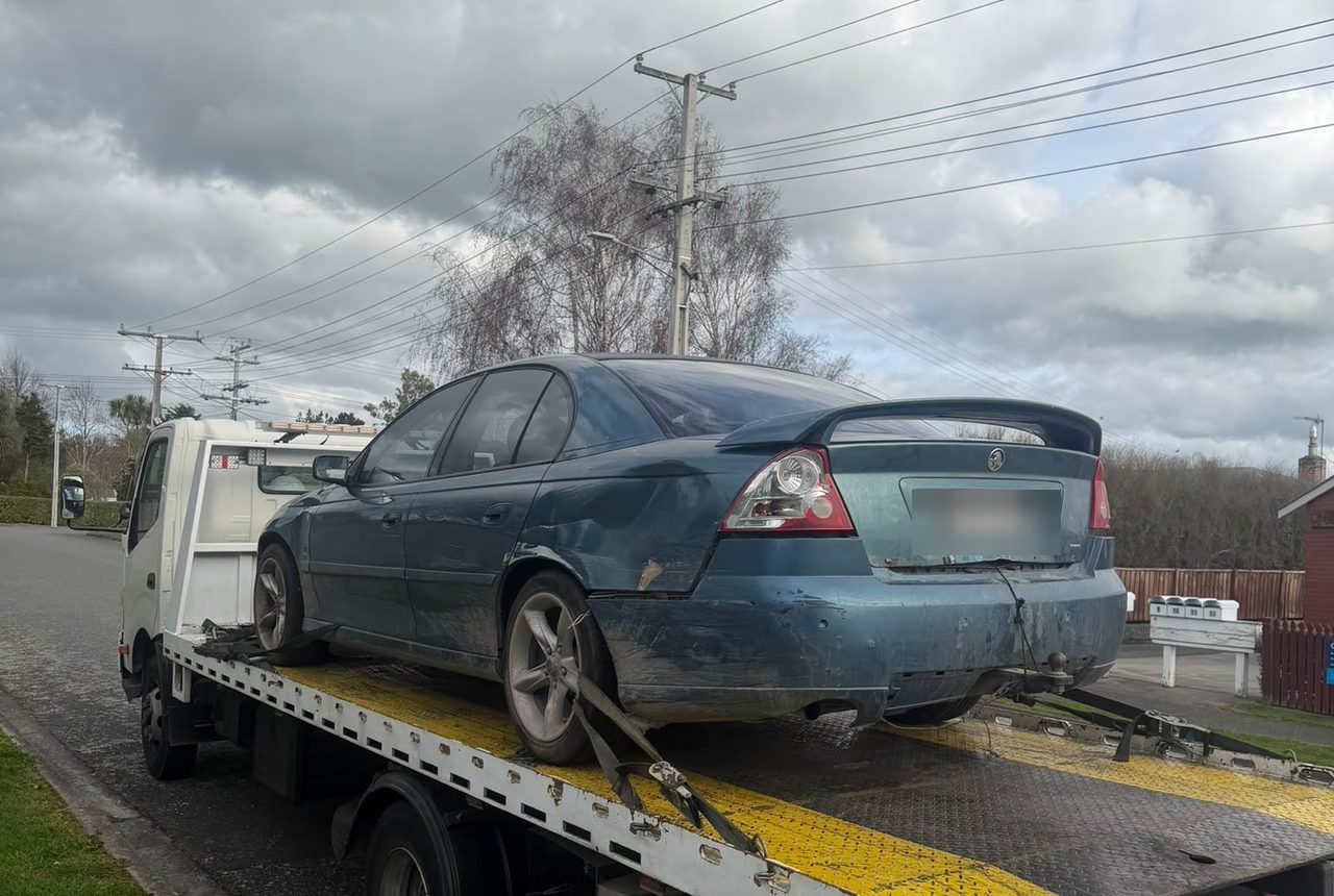 Car Wreckers Tauranga flatbed collecting a Holden Commodore across the Bay of Plenty